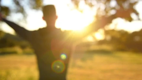 Young man raised hands outdoors and looking on sunset. Countryside Stock Footage