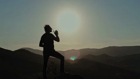 Young Man Reached the Top of the Mountain and Drinks From a Transparent Plastic Stock Footage 150592689