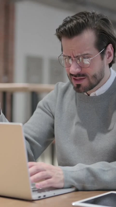 Young Man Reacting to Loss While using Laptop, Vertical Video Stock Footage 339580974