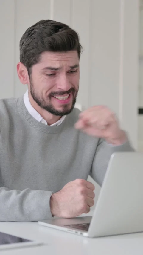 Young Man Reacting to Loss While using Laptop, Vertical Video Stock Footage 339581961