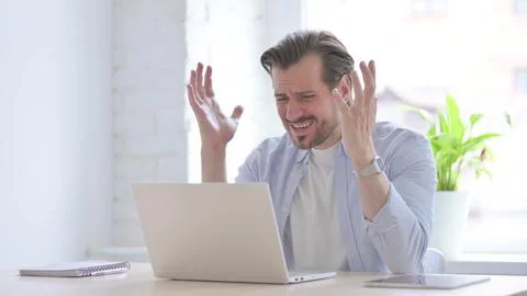Young Man Reacting to Loss While using Laptop Stock Photos