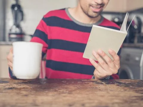 Young man reading and drinking coffee Stock Photos