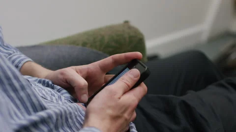 Young man reading and text messaging on his mobile phone Vídeo Stock 58581973