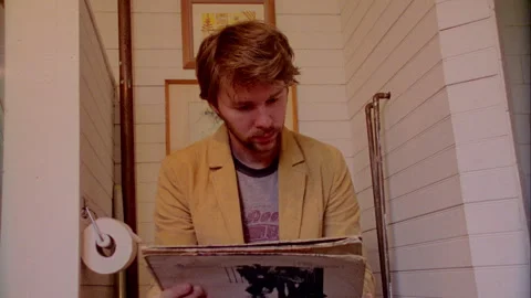 A young man is reading in the Bathroom Stock Footage 272310017