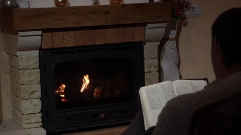 Young Man Reading The Bible In Front Of A Fireplace Belief Concept Stock Footage 44015023