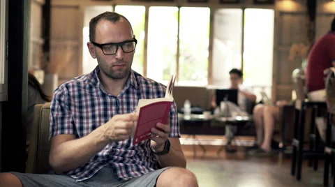 Young man reading book in cafe HD Stock Footage 51433529