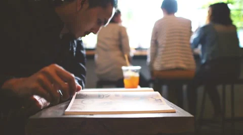 Young man reading book in cafe Stock Footage 58465165