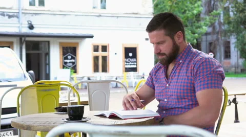 Young man reading book in cafe, slider shot right Vídeo Stock 67633221