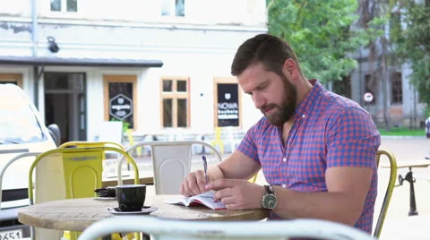 Young man reading book in cafe, slider shot left 库存影片 67633383