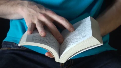 Young man reading a book, leafing through pages,slow motion Stock Footage 77087354