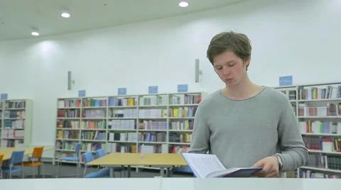Young Man Reading Book in Library Stock Footage 63045146