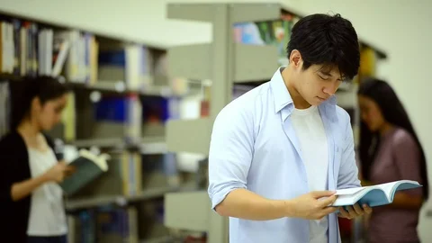 Young man reading book in library. Stock Footage 85670242