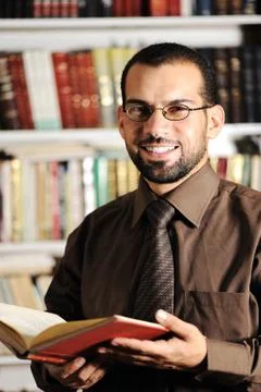 Young man reading book in library Stock Photos