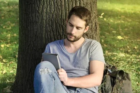 Young man reading e-book Stock-Fotos