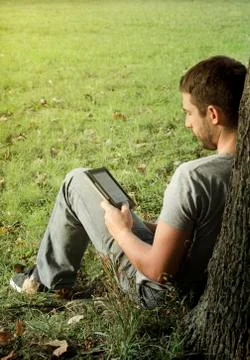 Young man reading e-book Stock-Fotos