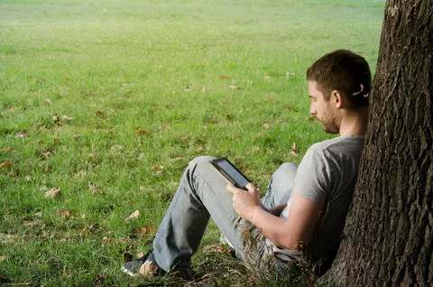.Young man reading e-book Stock Photos