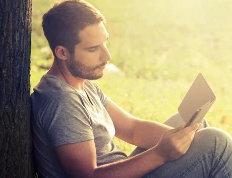 Young man reading e-book Stock-Fotos