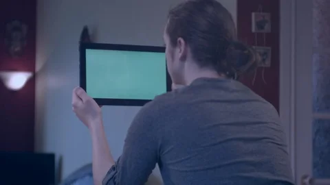 Young man reading on a green screen tablet Stock Footage 75278418