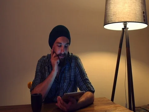 Young man reading his tablet and drink coffee 動画素材 72189755