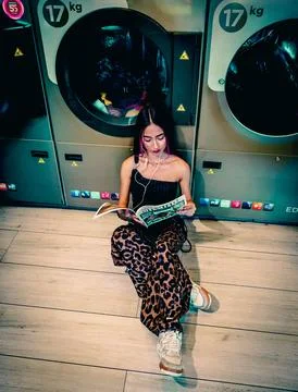 Young Man Reading In Laundry Foto stock