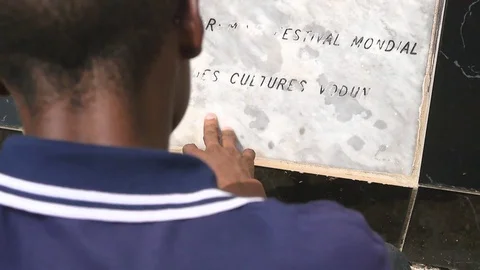 Young man reading memorial stele in Ouidah Stock Footage 81109535