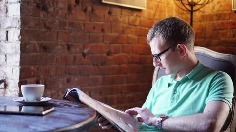 Young man reading menu sitting in cafe Video stock 73126424