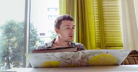 Young man reading menu sitting in cafe Stock Footage 93689479