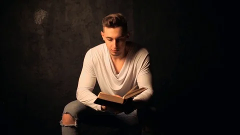 Young man reading an old book Stock Footage 100133812