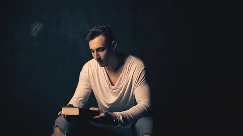 Young man reading an old book Stock Footage 100134114