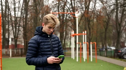 A young man reading online news and writes sms on smartphone. Video stock 144289727