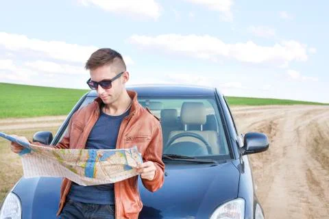 Young man reading road map Stock Photos