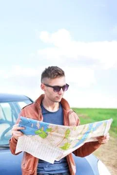 Young man reading road map Stock Photos