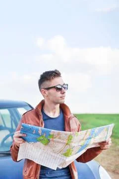 Young man reading road map Foto stock