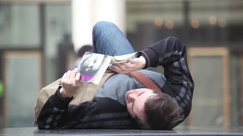 A young man reads a book lying. Vídeo Stock 47285045