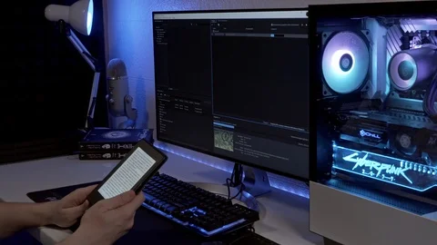 Young man reads an electronic book awaiting a final render of a video. Stock Footage 127534574