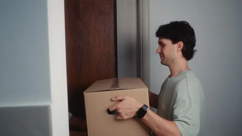 Young Man Receiving Package from Courier at Home Stock Footage 342323824