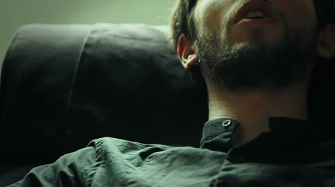 Young man reclining on a couch talking to his psychiatrist explaining some Stock Footage 32943051