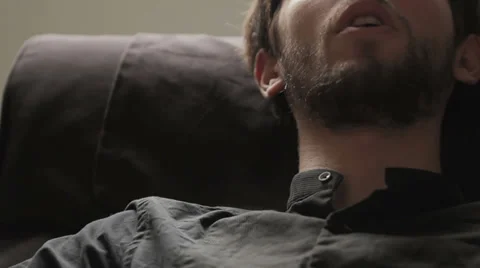 Young man reclining on a couch talking to his psychiatrist explaining some Stock Footage 32945166