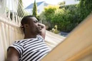 Young Man Reclining On Garden Hammock Stock Photos