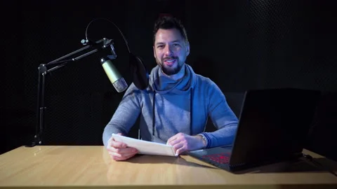 Young man in recording studio talking to the camera. He is holding pace of paper Stock Footage 169251008