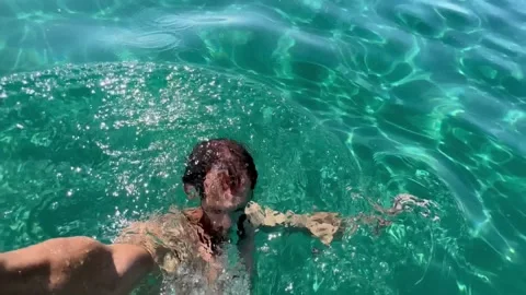 A young man records himself on video bathing in seawater on the background of th Stock Footage 251010657