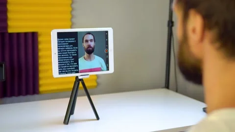 A young man records a video using a teleprompter on a tablet Stock Footage 167784755