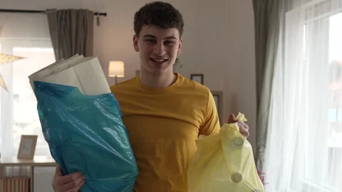Young man recycle at home sorting waste plastic paper and glass Stock Footage 264985174