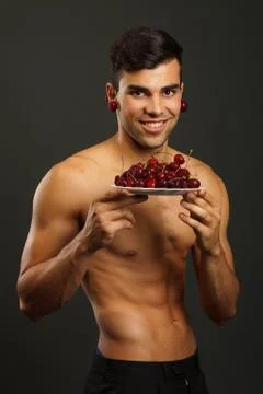 Young man with red cherry Stock Photos