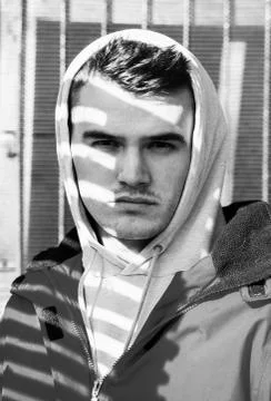 Young man in red jacket and cowl covered with beautiful light shadow Foto stock