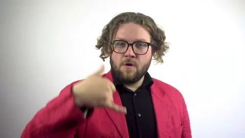 A young man in a red jacket looks at the camera and says you call me. Stock-Footage 137045254