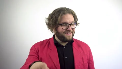 A young man in a red jacket looks at the camera and says you call me. Stock Footage 137104336