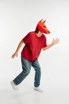 Young man in red t-shirt with cardboard animal mask on his head isolated on Stock Photos
