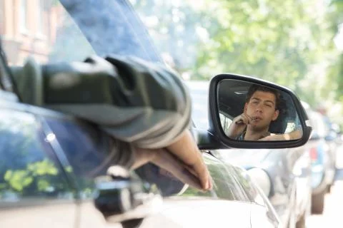 Young man reflection on car side mirror Stock Photos