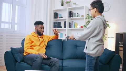 Young man refusing to play a game with his younger brother, bad relationship Stock Footage 201146557